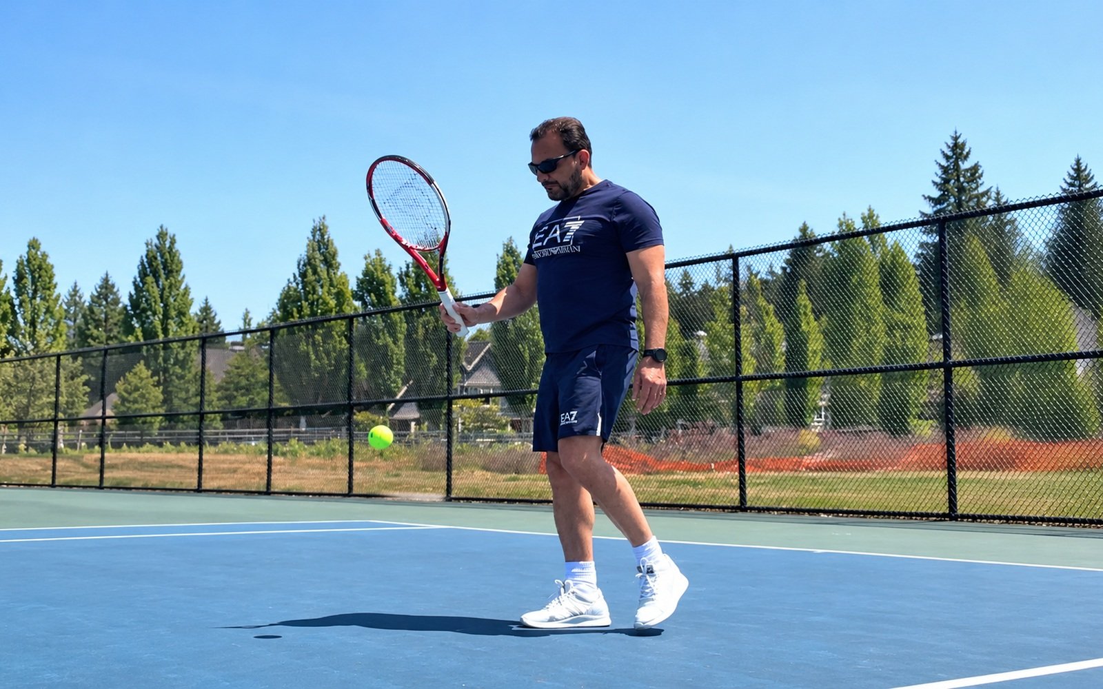 Dr. Fouad Alethawy playing tennis on an outdoor court
