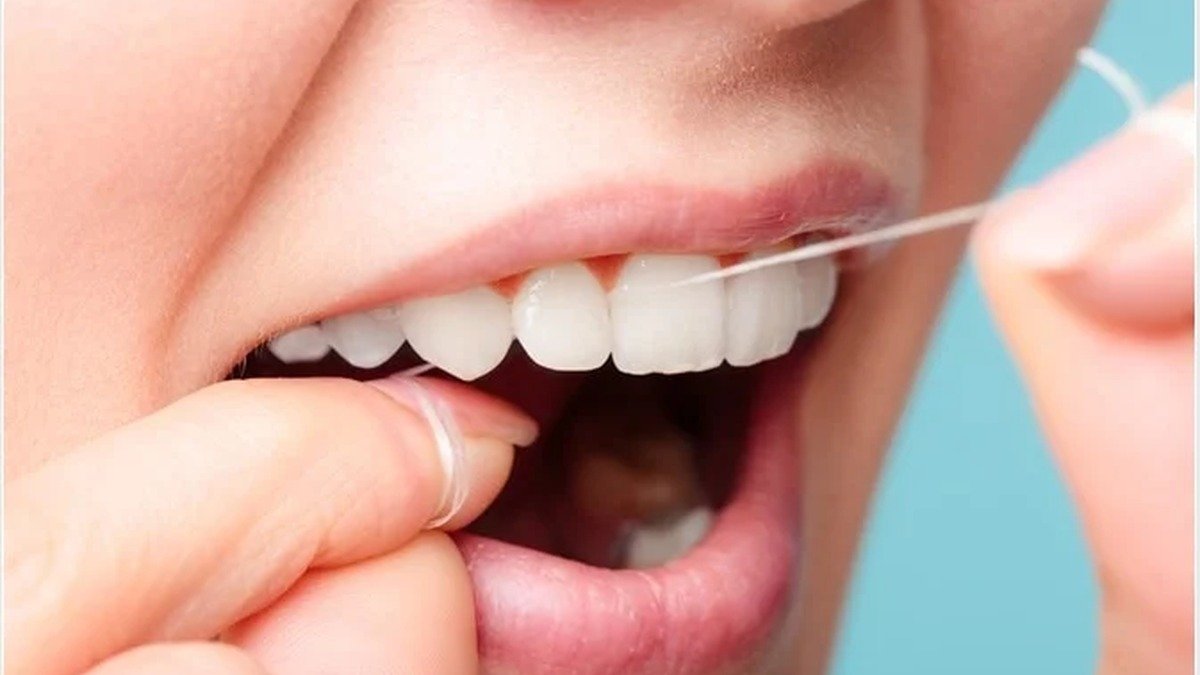 Close-up of dental floss being used between teeth